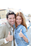 Portrait+of+smiling+couple+with+thumbs+up