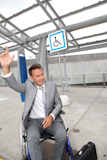 Businessman+in+wheelchair+calling+out+for+a+taxi