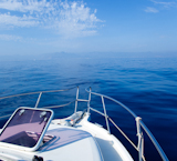 Blue+sea+boat+sailing+with+open+bow+porthole+in+summer+vacations