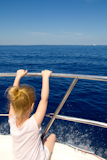 Blond+little+girl+rear+view+sailing+in+boat+in+blue+Ibiza+sea