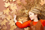 autumn+fall+little+blond+girl+on+dried+tree+leaves+background+and+long+spread+hair