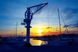 boats+crane+at+sunset+in+marina+port+of+Salou+Tarragona+Spain