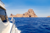 Ibiza+yacht+reaching+Es+Vedra+island+in+Mediterranean+blue+sea