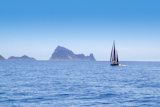 Ibiza+Red+sails+sailboat+in+Es+Vedra+at+blue+mediterranean+sea+of+Balearic