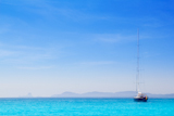 Ibiza+mountains+with+sailboat+from+Formentera+turquoise+sea
