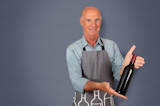 Portrait of senior winemaker holding bottles of wine