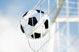 Soccer ball going into goal net ,selective focus