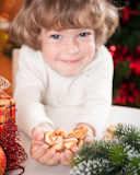 Funny,child,holding,cookies,against,Christmas,lights,background
