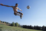 Man+Kicking+Soccer+Ball+in+Mid+Air