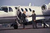 Man+Greeting+Businessman+Stepping+Off+Plane