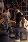 Teenage+Boys+Standing+Around+Dirt+Bike+In+Garage