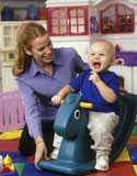 Little+Boy+Laughing+With+Teacher+While+Riding+Toy+Horse