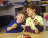 Children+Eating+Apples+And+Laughing+In+Classroom