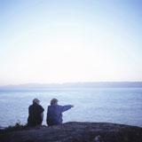 Elderly+Couple+Sitting+On+A+Rock+Overlooking+The+Sea