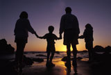 Family+Standing+on+the+Beach+at+Sunset