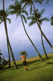 Surfer+Walking+Through+Palm+Trees+to+the+Beach