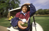 Elderly+Man+Holding+Golf+Ball+On+Tee+In+Front+Of+Golf+Cart