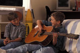 Boy+Playing+Guitar+For+Friend+And+Laughing