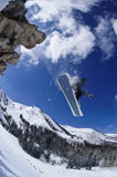 Low+angle+view+of+a+snowboarder+jumping+off+a+slope