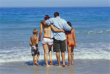 Rear+view+of+parents+with+their+son+and+daughter+on+the+beach