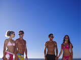 Low+angle+view+of+two+young+couples+standing+on+the+beach