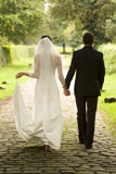 Rear+view+of+a+young+bride+and+groom+walking+in+a+garden