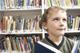 Little+boy+holding+blue+book+in+library+1