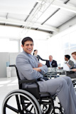 Attractive,businessman,sitting,in,a,wheelchair,with,folded,arms