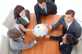 High Angle of Business team holding a globe and businessman smiling upwards.
