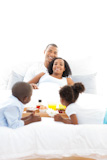 Joyful family having breakfast in the bedroom