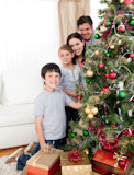 Happy,family,decorating,a,Christmas,tree,with,boubles,and,presents