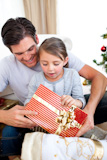 Surprised,little,girl,holding,a,Christmas,present,with,her,father