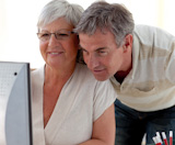 Portrait of senior couple using a PC at home