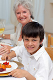 Smiling boy having dinner with his family