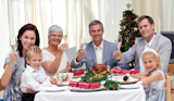 Family tusting in a Christmas dinner with white wine
