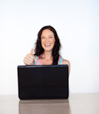 Happy woman with laptop and thumb up