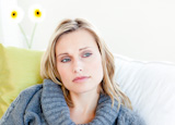 Exhausted woman lying on the sofa with a grey pullover