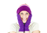 Positive woman with a colorful hat and a pullover smiling at the camera