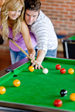 Affectionate boyfriend learning his girlfriend how to play pool