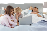 Attentive,boy,using,a,laptop,with,his,sister,while,their,parents,are,sleeping