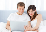 Young couple watching videos on their PC at home