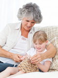 Grandmother helping her granddaughterl to knit