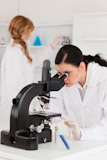 Two female scientists working with a microscope