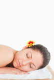 Eyes closed brunette with a flower on her ear
