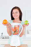 Happy,woman,with,a,blender,and,fruits
