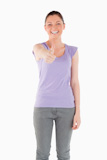 Good looking woman posing with her thumb up while standing