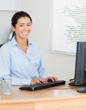Charming woman working on a PC while sitting