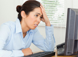 Attractive upset woman looking at a PC screen while sitting