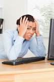 Pretty upset woman looking at a PC screen while sitting