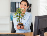 Attractive woman holding a plant while looking at the camera